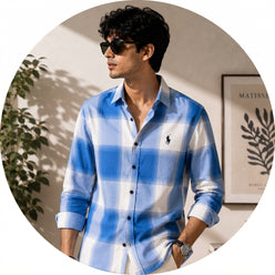 A professional portrait of Varun Varma wearing a blue and white check shirt against a clean, softly lit background.