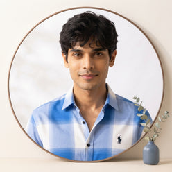 Portrait of a South Asian man wearing a blue and white check shirt against a clean white background.